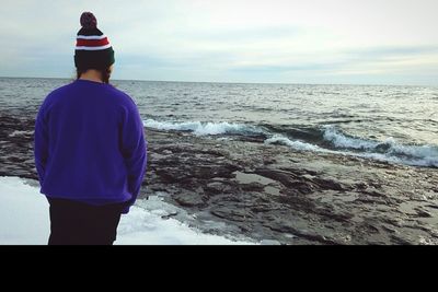 Rear view of a man overlooking sea