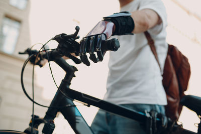 Midsection of man photographing bicycle