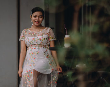 Portrait of a smiling young woman standing outdoors