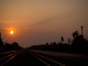 Railroad tracks against sky during sunset