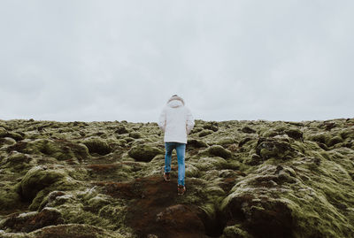 Full length of man standing on rock against sky