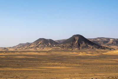 Scenic view of arid landscape against clear sky