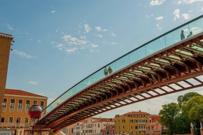 Low angle view of bridge and buildings against sky