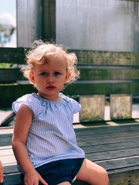 Portrait of cute girl sitting on bench