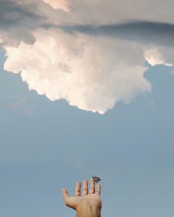 Midsection of woman holding umbrella against sky