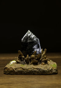 Close-up of rock on table against black background