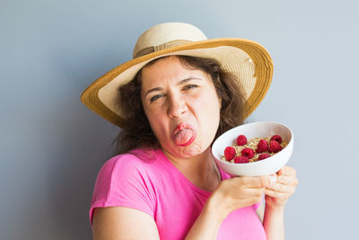 Portrait of woman wearing hat against white background