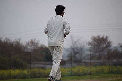 Rear view of man standing on field