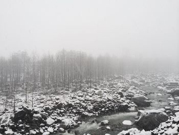 Snow covered landscape against clear sky