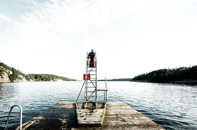 Rear view of people on lake against sky