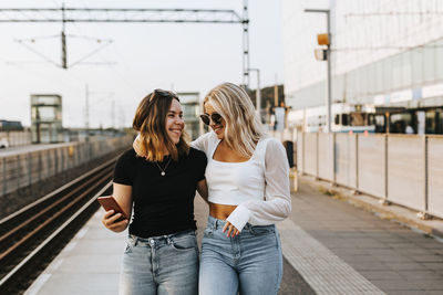 Smiling women at train station platform