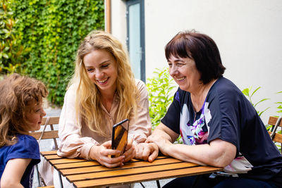 Two women sitting on table