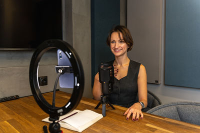 Portrait of young woman standing against wall