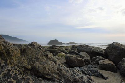 Rocks on sea shore against sky