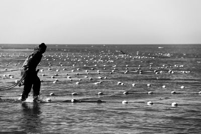 Man standing on beach against clear sky