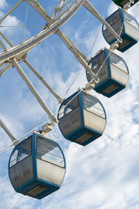 Closeup of colorful cabins of giant ferris wheel in amusement park against blue sky