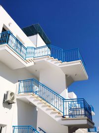 Low angle view of staircase by building against clear blue sky