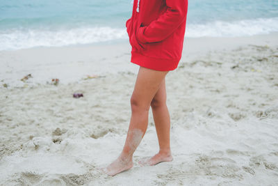 Low section of woman standing a beach