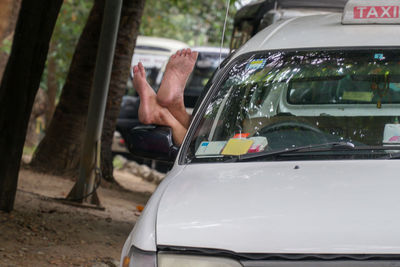 Feet of taxi driver hanging out of the car window, yangon myanmar