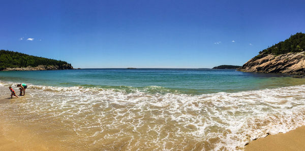 Scenic view of sea against blue sky on sunny day