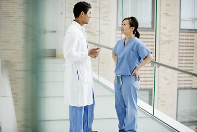 Doctors discussing while standing in hospital