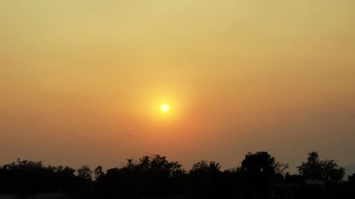 Low angle view of silhouette trees against romantic sky at sunset