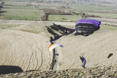 High angle view of people doing paragliding over landscape