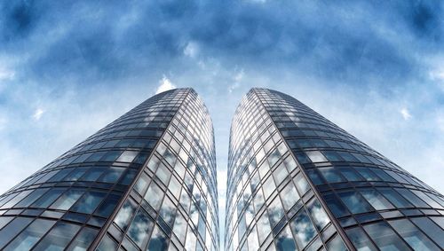 Low angle view of modern building against cloudy sky