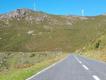 Road leading towards mountain against sky