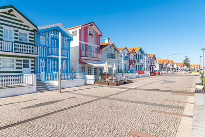 Houses by street against sky in city