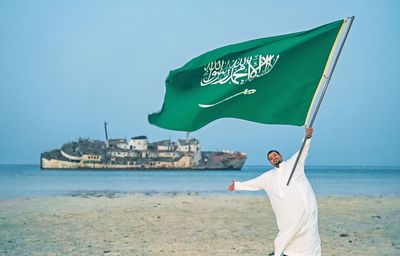 Man standing at beach against sky