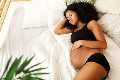 Pregnant woman sleeping on bed