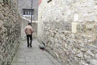 Rear view of man walking on footpath