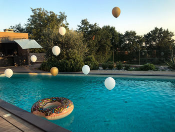 View of balloons in swimming pool against trees