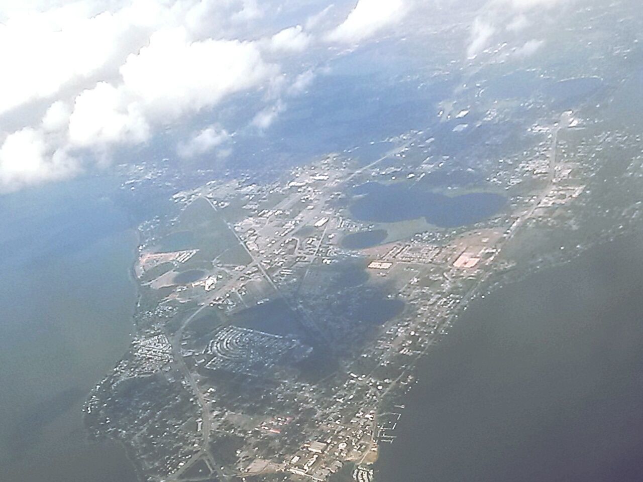 aerial view, scenics, water, sea, high angle view, beauty in nature, tranquility, tranquil scene, landscape, nature, mountain, sky, transportation, idyllic, day, cloud - sky, outdoors, no people, mode of transport, coastline