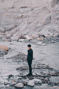 Rear view of man standing on rock