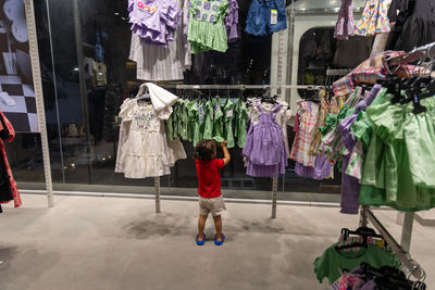 Child selecting clothes at indoor shopping mall