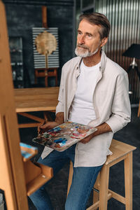 Midsection of man holding umbrella on table