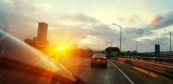 Cars on street in city at sunset