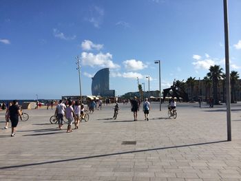 People in city against cloudy sky