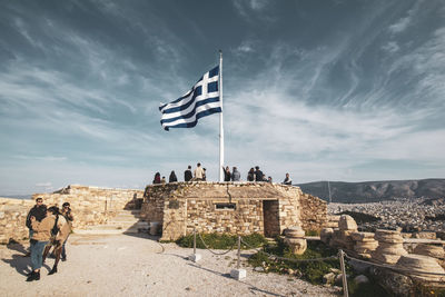 People at historical building against sky