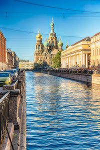 Canal amidst buildings against sky in city