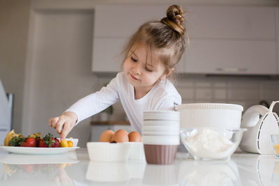 Side view of girl eating food at home