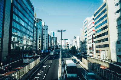 Vehicles on road in city against clear sky