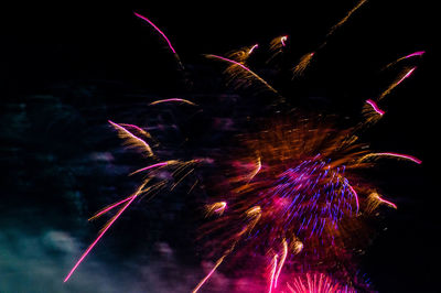 Low angle view of firework display at night