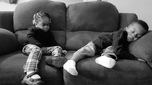 Boy and girl sleeping on sofa