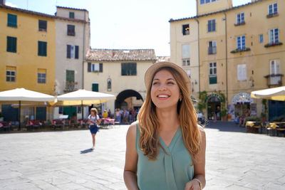 Discovering italy. cheerful young woman visiting the historic city of lucca, tuscany, italy.