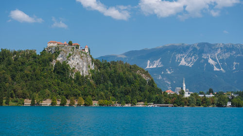 Buildings by sea against sky