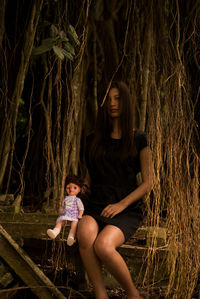 Young woman sitting on tree trunk