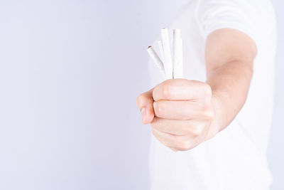 Close-up of man holding hands over white background